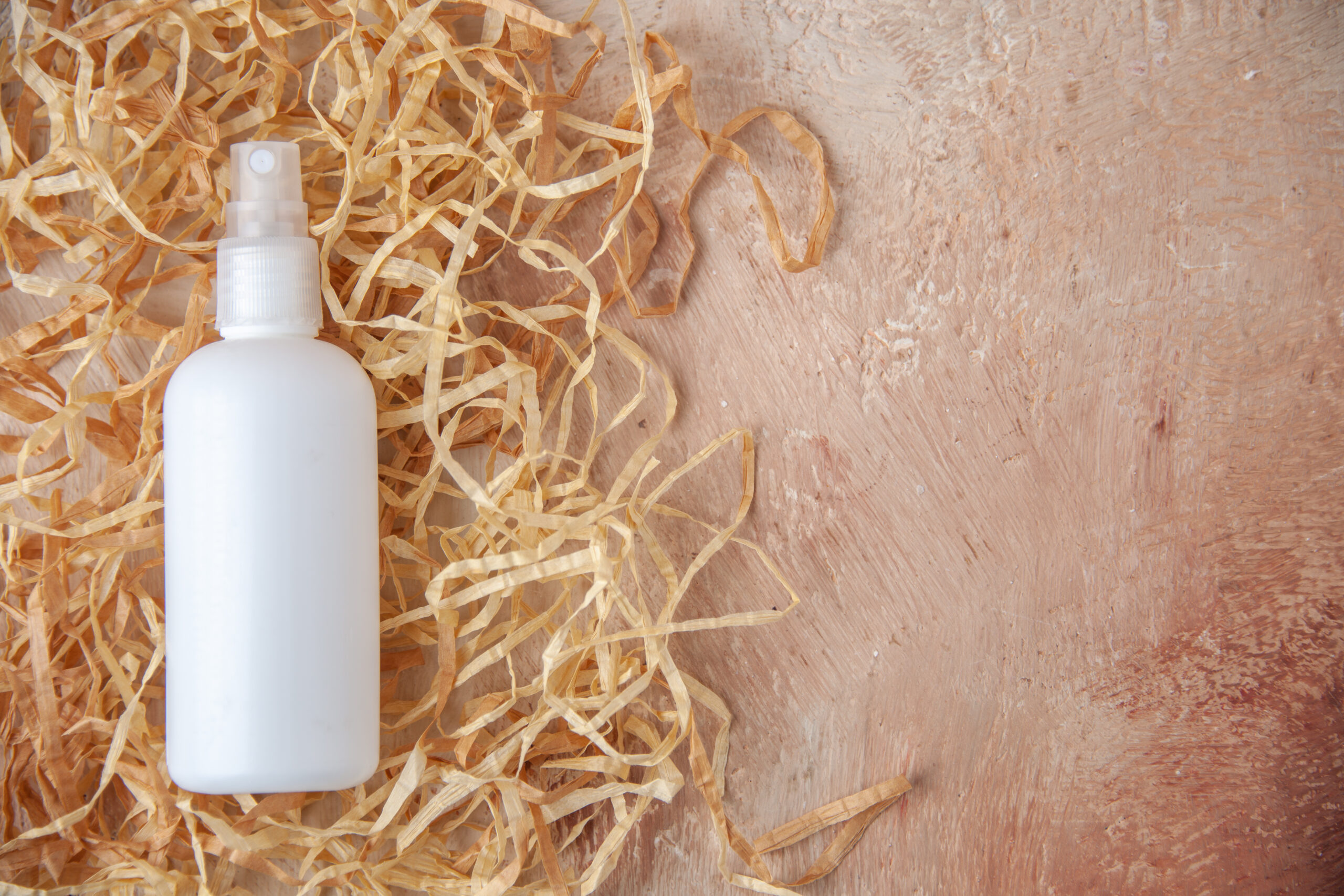 top-view-white-spray-bottle-nude-background